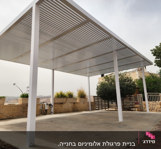 פרגולה מאלומיניום עם קורות לבנות על משטח בטון